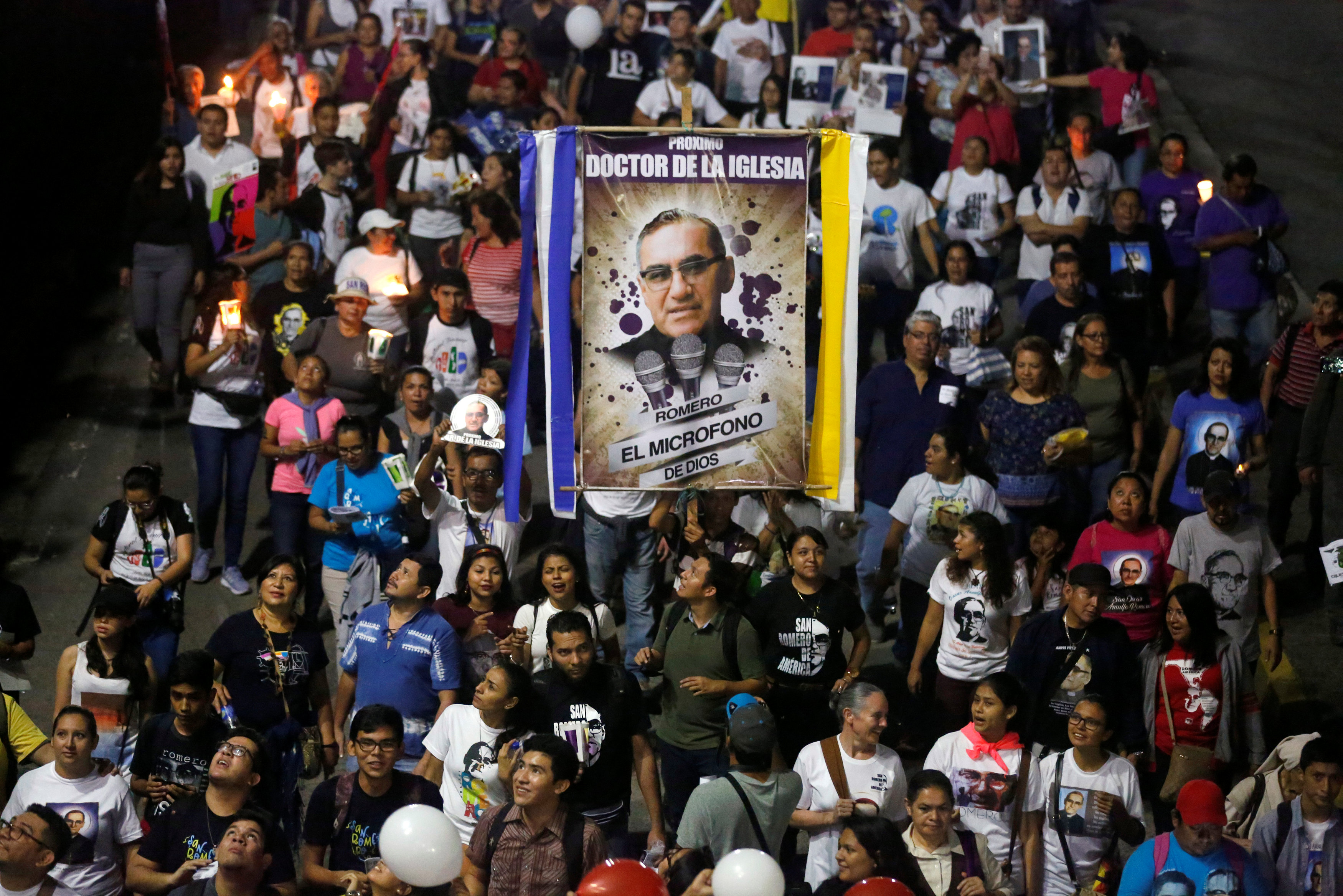 People carry a banner of St. Oscar Romero during an Oct. 13 procession in San Salvador, El Salvador. Pope Francis celebrated the canonization Mass for St. Oscar Romero and six other new saints in St. Peter's Square Oct. 14 at the Vatican. (CNS photo/Jose Cabezas, Reuters)