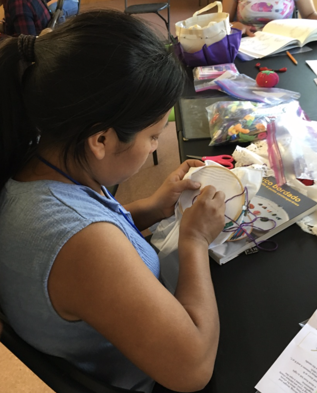 A migrant woman embroiders at the Casa Alitas monastery shelter for asylum seekers in Tucson, Ariz. (Photo provided by author)