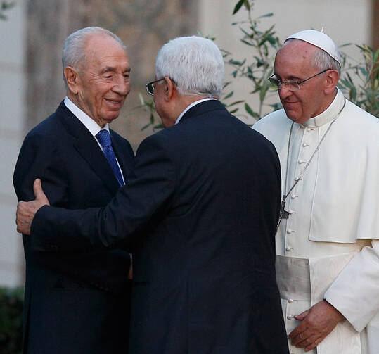 Pope Francis looks on as Israeli President Shimon Peres, left, and Palestinian President Mahmoud Abbas embrace at the Vatican. (CNS/Paul Haring)