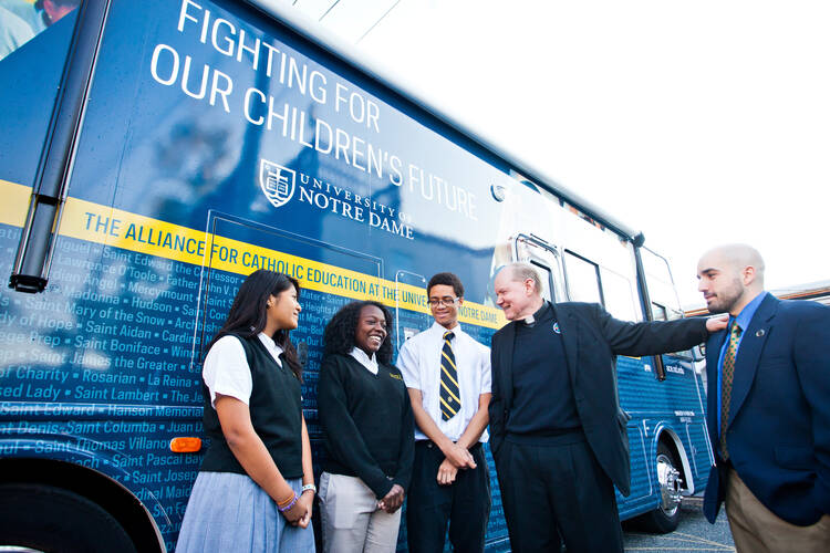 Stundets from Cristo Rey Jesuit High School in Baltimore talk with Holy Cross Father Timothy Scully from the University of Notre Dame and Cristo Rey teacher Lee Imbriano.