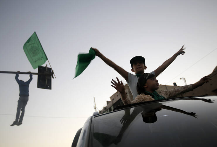 Palestinians celebrate a cease-fire in Gaza City Aug. 26. Catholic aid officials say they hope the Egyptian-brokered Israeli-Hamas cease-fire proposal will hold. (CNS photo/Mohammed Saber, EPA)