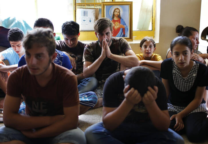 Displaced Iraqi Christians who fled from Islamic State militants pray at school acting as refugee camp in Irbil. (CNS photo/Ahmed Jadallah, Reuters)