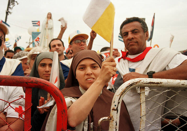 A nun waves a Vatican flag while attending Mass with Pope John Paul II in Havana Jan. 25, 1998.
