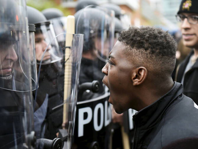 A demonstrator confronts police near Camden Yards during a march to protest the death of Freddie Gray in Baltimore April 25. (CNS photo/Sait Serkan Gurbuz, Reuters)