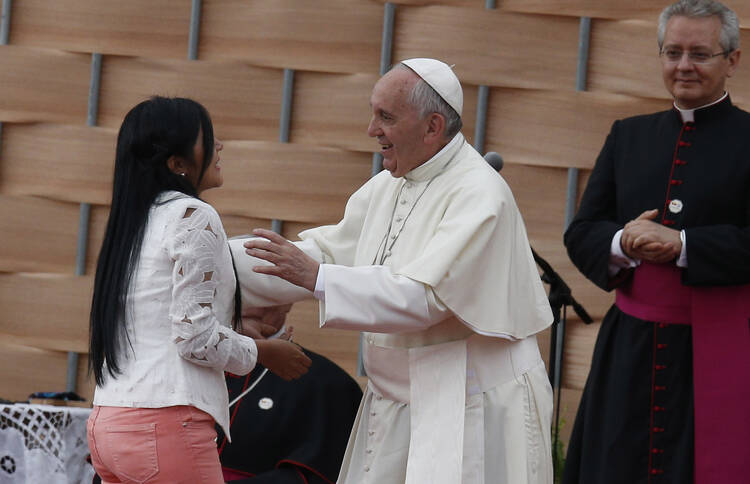 Pope Francis greets a young woman who gave a testimonial during a meeting with representatives of schools and universities at the Pontifical Catholic University of Ecuador in Quito July 7. (CNS photo/Paul Haring)