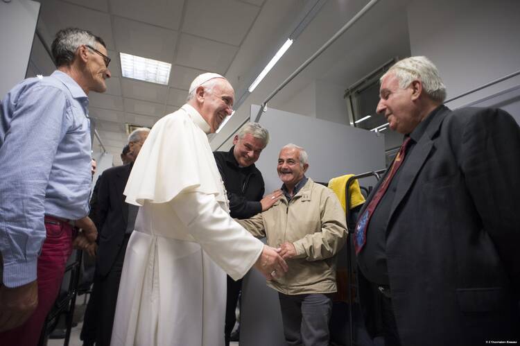 Pope Francis greets people as he visits a new homeless shelter for men in Rome Oct. 15. Housed in a Jesuit-owned building, the shelter was created by and is run with funds from the papal almoner. (CNS photo/L'Osservatore Romano, handout)