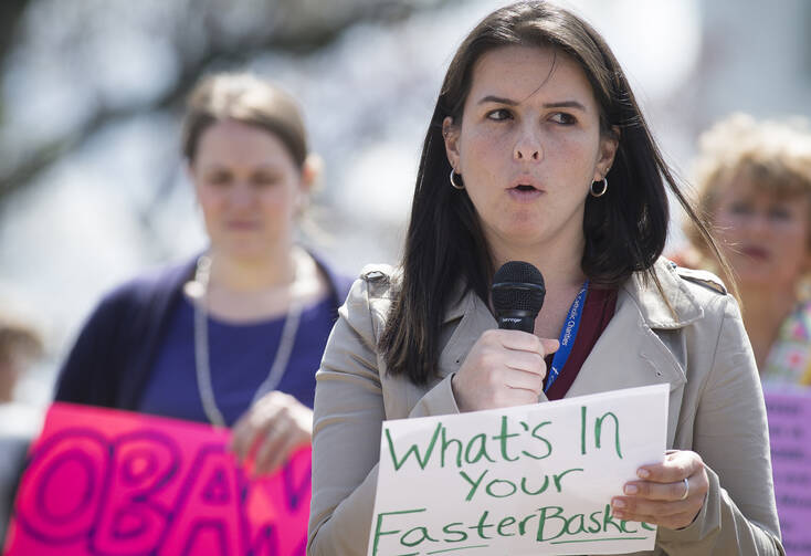 Attorney Isabel Saavedra speaks during a rally in front of the White House in Washington March 28 calling for an end to the detention of immigrant families who are seeking asylum. (CNS photo/Tyler Orsburn)
