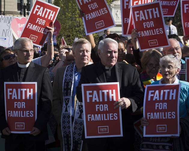 Representatives of faith-based groups gather outside the U.S. Supreme Court in Washington on April 18 as the justices hear oral arguments in a challenge by several states to President Barack Obama's deferred deportation programs. (CNS photo/Tyler Orsburn)