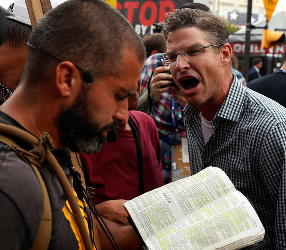 A protester against Donald Trump's candidacy screams at a man reciting passages from Scripture July 18 outside of the Republican National Convention in Cleveland. (CNS photo/Lucas Jackson, Reuters)