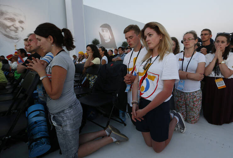 World Youth Day pilgrims kneel in prayer July 30 as Pope Francis leads the benediction during a prayer vigil at the Field of Mercy in Krakow, Poland. (CNS photo/Paul Haring) 