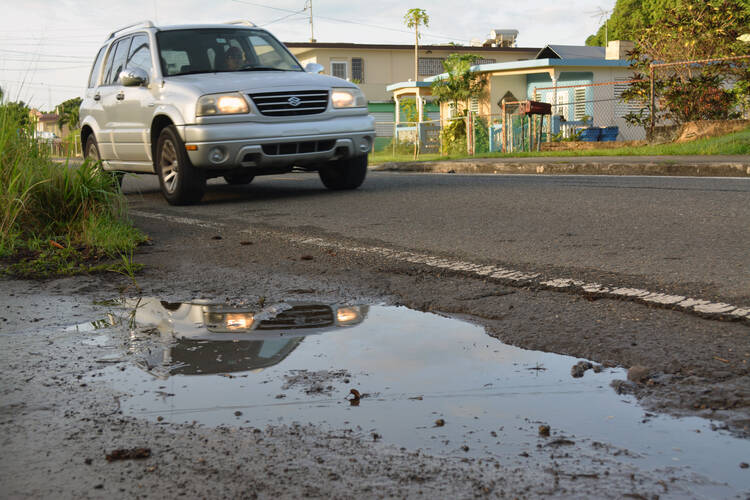 Puddle Warning. A street puddle is seen in San German, Puerto Rico, in this undated photo. Puddles of water contribute to the spread of Zika in Puerto Rico. (CNS photo/CNS photo/Wallice J. de la Vega)