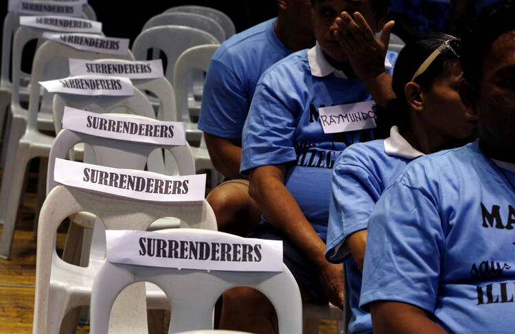 Filipino residents in Manila involved with illegal drugs wait to take a pledge that they will not use or sell narcotics after surrendering to police and government officials Aug. 18. (CNS photo/Erik De Castro, Reuters)