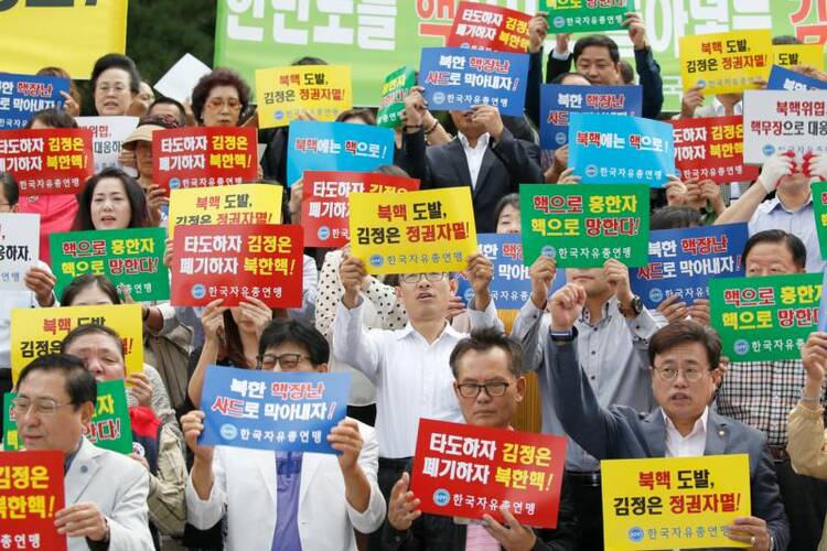 South Korean activists shout slogans as they hold up banners reading "Overthrow North Korean leader Kim Jong-un," during a Sept 12 protest in Seoul against North Korea's fifth nuclear test. (CNS photo/Jeon Heon-Kyun, EPA)