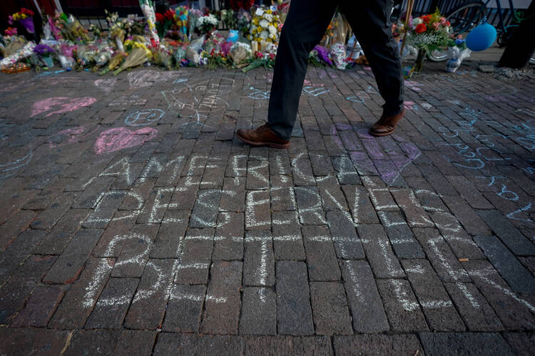 A man walks past a memorial on Aug. 7, 2019, for those killed in a mass shooting in Dayton, Ohio, four days earlier. Three U.S. bishops' committee chairmen issued a statement Aug. 8 to call on the nation's elected officials "to exert leadership in seeking to heal the wounds" of the country caused by the Aug. 3 and 4 mass shootings and urged an end to hateful rhetoric many see as a factor in the violence particularly in Texas. The Aug. 3 shooting in El Paso, Texas, was followed less than 24 hours later by th