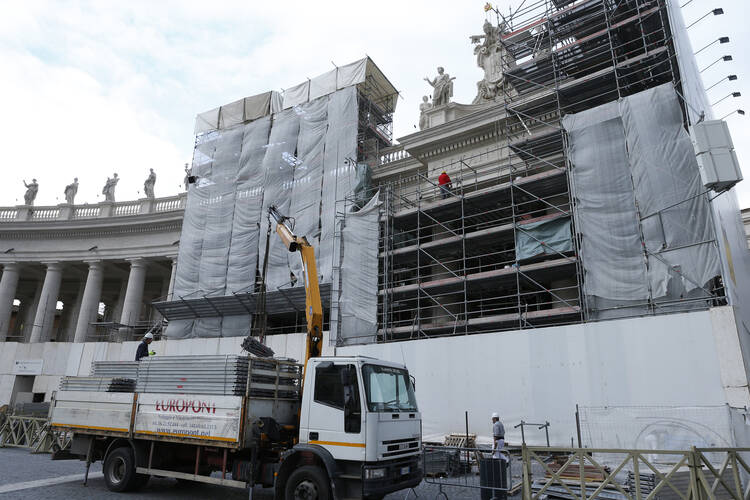 Vatican workers remove scaffolding from the final restored section of the colonnade in St. Peter's Square at the Vatican in this January 2014 file photo. Pope Francis issued a new set of laws June 1, 2020, that govern the awarding of contracts for goods and services provided by outside vendors. (CNS photo/Paul Haring)