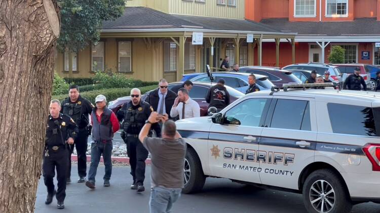 Police officers in Half Moon Bay, Calif., detain a man believed by law enforcement to be the Half Moon Bay mass shooting suspect.