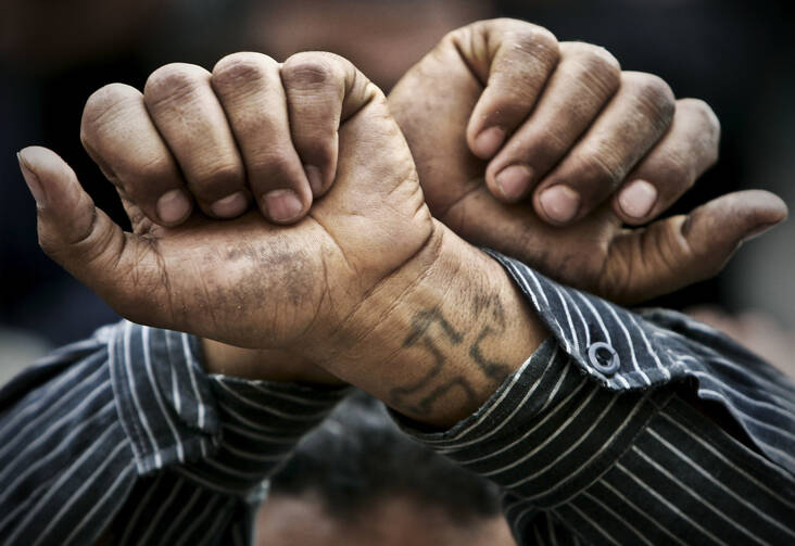 In this Friday, April 14, 2006 file photo, Egyptian Copts cross their wrists in defiance outside the Saints Church in the Sidi Bishr district of Alexandria in Egypt. Egypt’s Coptic Christians have become the preferred target of Islamic State radicals operating in the Arab world’s most populous nation, seeking to sow discord, undermine President Abdel-Fattah el-Sissi, and split the country. (AP Photo/Ben Curtis, File)