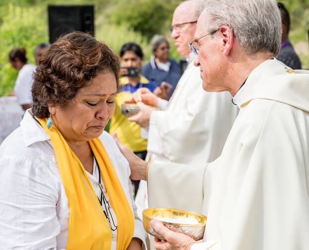 Father John I. Jenkins, president of the University of Notre Dame in Indiana, comforts a woman while distributing Communion during Mass on Oct. 15 with the Colectivo Solecito near Veracruz, Mexico. (CNS photo/Matt Cashore, University of Notre Dame)