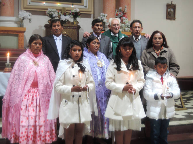 Father Sebastian Obermaier poses for a photo with three children and their families after a baptism in El Alto, Bolivia, July 4. (CNS photo/David Agren) 