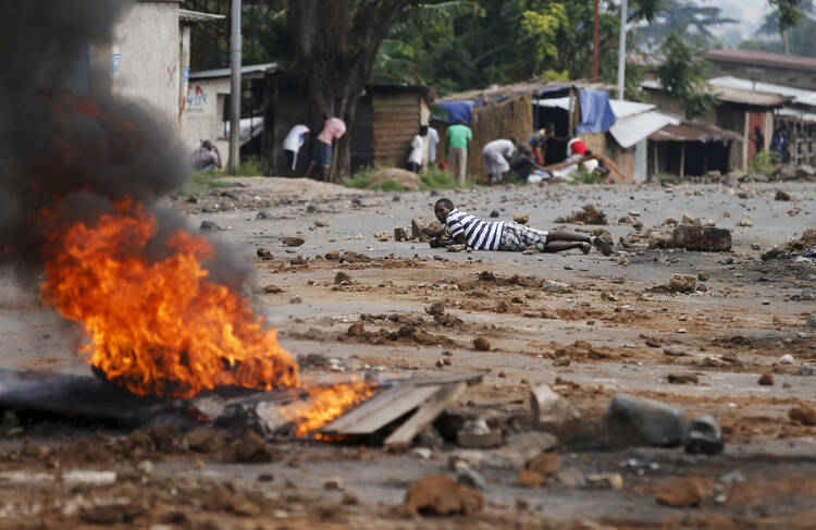 Demonstrators in Bujumbura, Burundi, take cover during a May 20 protest against President Pierre Nkurunziza and his bid for re-election. (CNS photo/Goran Tomasevic, Reuters) 