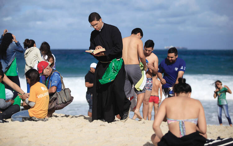 BEACH READING: A priest reads the Bible as he waits for the arrival of Pope Francis on Copacabana Beach during World Youth day in Rio de Janeiro on July 26.