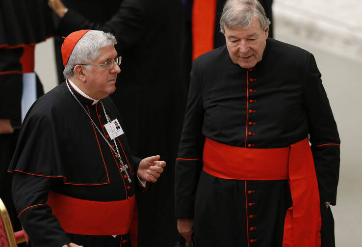 Cardinal Thomas Collins of Toronto and Australian Cardinal George Pell talk after an event marking the 50th anniversary of the Synod of Bishops in Paul VI hall at the Vatican, Oct. 17 (CNS Photo / Paul Haring).