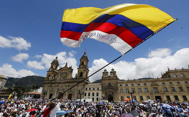 A man waves a national flag during the "March For Life" March 8, 2015 in Bogota, Colombia. The event supported peace negotiations between the government and the Revolutionary Armed Forces of Colombia (CNS photo/John Vizcaino, Reuters).