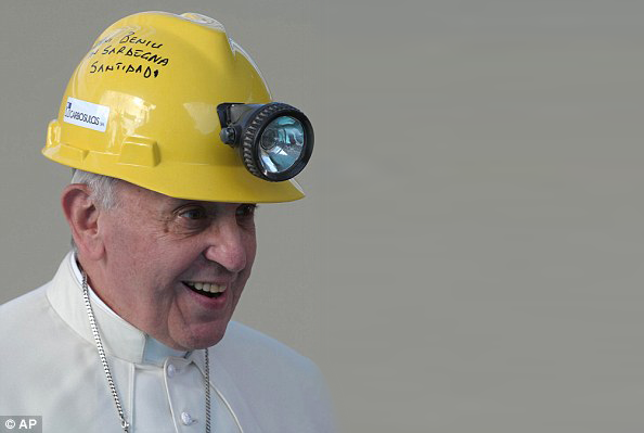 pope francis wearing a yellow safety helmet, he is smiling and wearing his white papal clothing