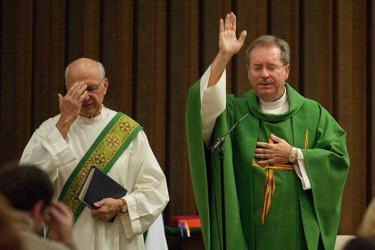 Father Gary Thomas, right, pastor of Sacred Heart Church in Saratoga, Calif., gives the final blessing during Mass Oct. 31., 2010 