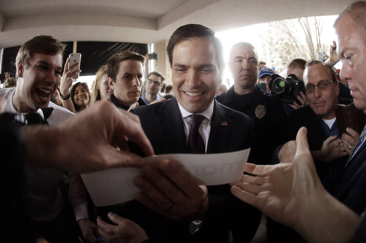 Republican presidential candidate Sen. Marco Rubio of Florida autographs a bumper sticker after speaking at a rally Sunday in Franklin, Tenn. (AP Photo/Mark Humphrey)