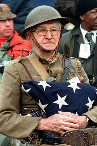 Joseph Ambrose, an 86-year-old World War I veteran, attends the dedication day parade for the Vietnam Veterans Memorial in 1982, holding the flag that covered the casket of his son, who was killed in the Korean War. (Courtesy, Wikipedia)