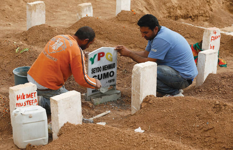 Men place headstone at grave of fighter killed during clash with ISIS