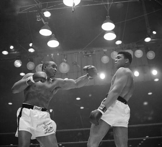 In this Feb. 26, 1964 file photo, Muhammad Ali (Cassius Clay) uses a variety of bobbing and weaving to stay clear of the left arm of Sonny Liston in their title fight in Miami Beach, Fla. (AP Photo)