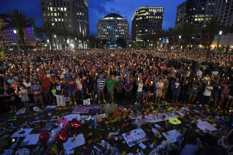 Thousands gather outside the Dr. Phillips Performing Arts Center for a vigil Monday, June 13, 2016 in Orlando, Fa. A large crowd gathered to remember the Pulse nightclub shooting victims early Sunday. (Chris Urso/Tampa Bay Times via AP)