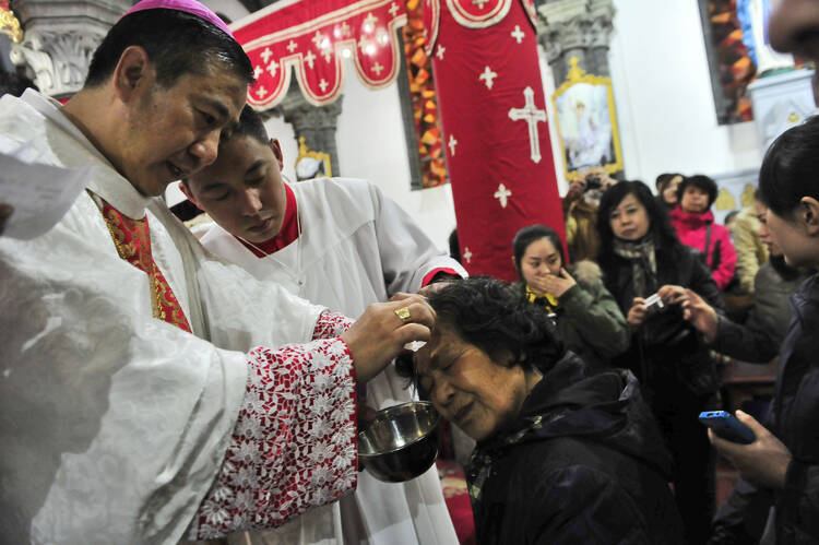 Chinese Catholic priests baptize new believers during a 2013 Easter Vigil in a church in Shenyang, China (CNS photo/EPA). 
