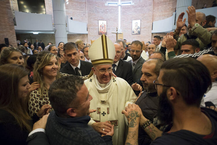 Pope Francis greets inmates after celebrating Mass on Holy Thursday, April 2, at Rebibbia prison in Rome. The pope regularly visits with prisoners, a practice he began while archbishop of Buenos Aires. (CNS photo/L'Osservatore Romano via Reuters)