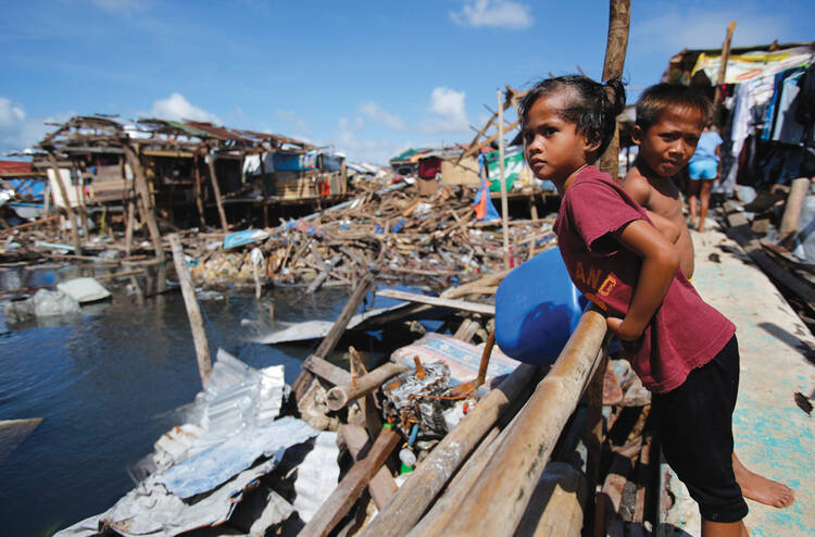 STORM WARNING. A girl reviews the devastated waterfront of Guiuan, Philippines, on Nov. 19. Did global warming contribute to the ferocity of Typhoon Haiyan?