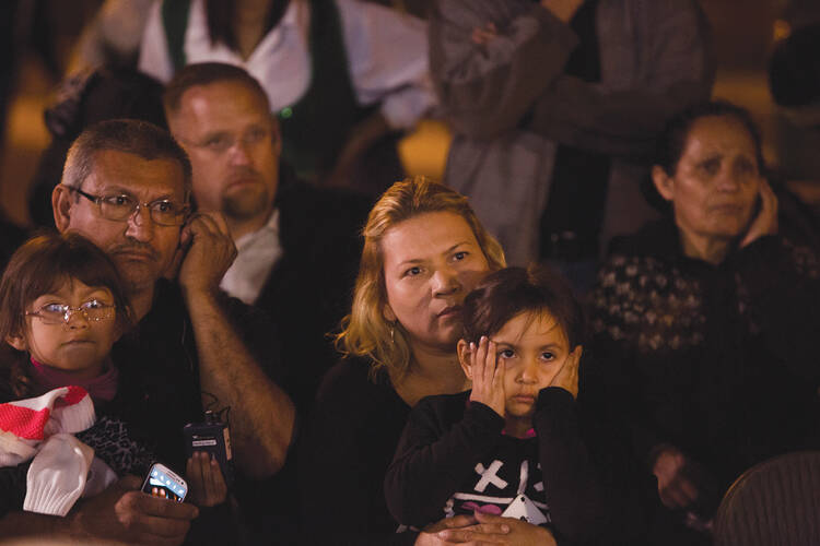 EYES ON THE PRIZE. Outside the Arizona Capitol in Phoenix, Abel and Idalia Rodríguez watch a live broadcast as President Obama describes his plan for immigration reform on Nov. 20.