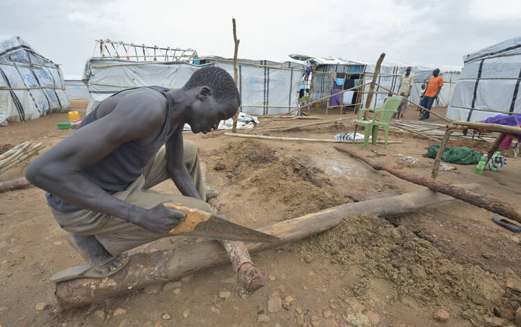 A man constructs a shelter inside a U.N. base in Juba, South Sudan, March 7. Church leaders in South Sudan are trying to breathe new life into their country'­s stalled peace talks. (CNS photo/Paul Jeffrey)