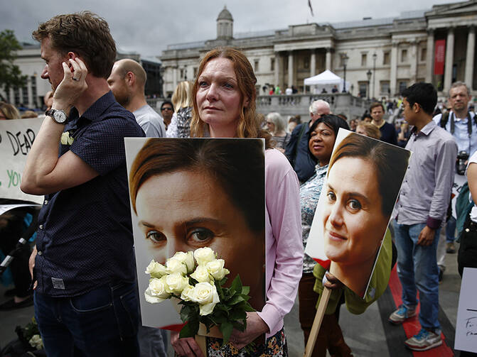 woman holds a placard and white roses during a special service for slain Labour Party MP Jo Cox, at Trafalgar Square in London, on June 22, 2016. Photo courtesy of REUTERS/Peter Nicholls