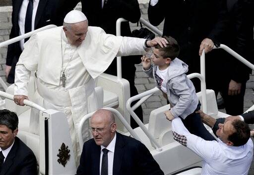 Pope Francis caresses a child as he makes a tour of St. Peter's Square at the end of a Mass for the the Holy Year of Mercy, at the Vatican, Sunday, April 3, 2016. (AP Photo/Alessandra Tarantino)