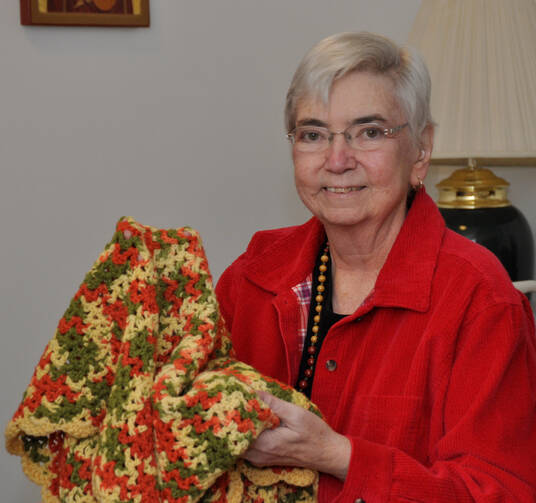 Mercy Sister Mary Ann Walsh takes comfort in a prayer shawl given to her by a former colleague in this 2014 photo taken at the Mercy Motherhouse in Albany, N.Y. (CNS photo/courtesy Catherine Walsh, Northeast Communications for the Sisters of Mercy)