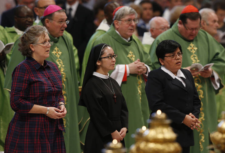 Women wait to read intentions as Pope Francis celebrates Mass of Thanksgiving for canonization of two Canadian saints.