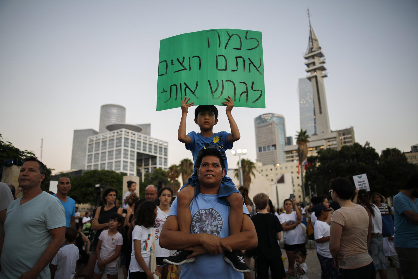 A child holds a sign at a protest.