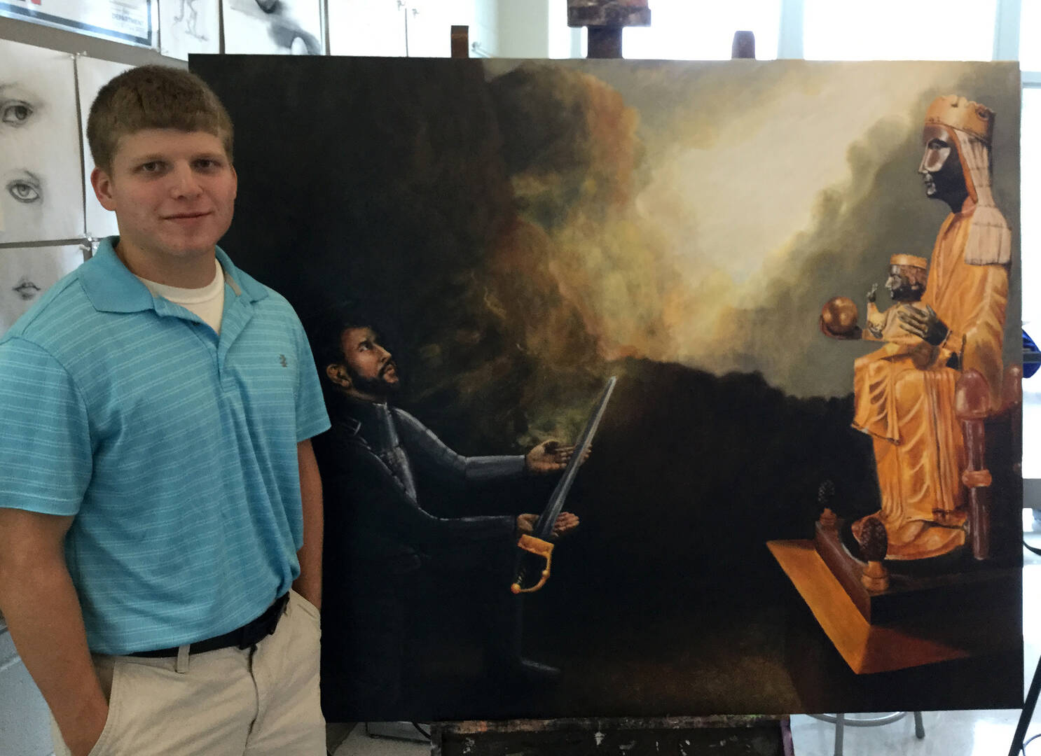 Nic Thurman stands before his painting of St. Ignatius laying his sword before a statue of the black Madonna