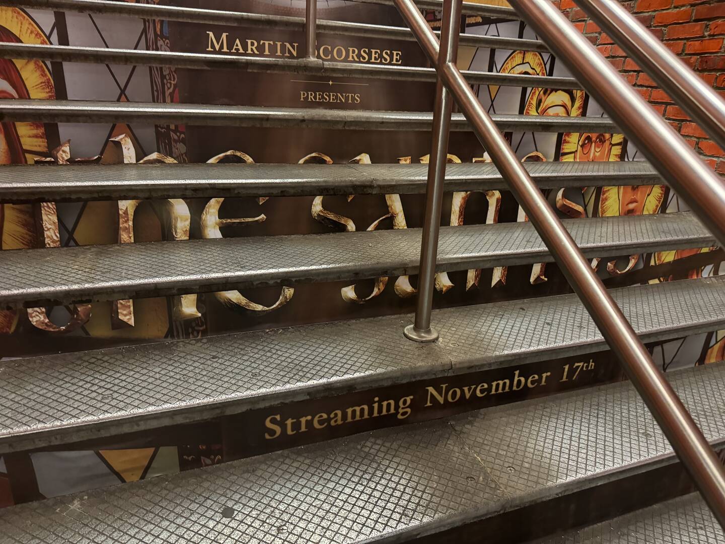 An ad for 'Martin Scorsese Presents: The Saints' on subway steps in Manhattan