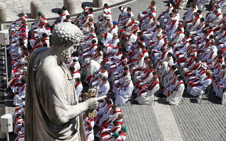 Priests sit below the statue of St. Peter as Pope Francis celebrates Mass marking the feast of Sts. Peter and Paul in St. Peter's Square at the Vatican on June 29, 2018. (CNS photo/Paul Haring)