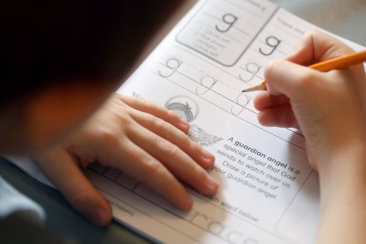 A student works in his "Writing Our Catholic Faith" handwriting book during a homeschool lesson July 29, 2020. (CNS photo/Karen Bonar, The Register)