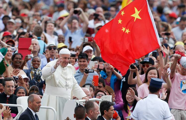 China's flag is seen as Pope Francis greets the crowd during his general audience in St. Peter's Square at the Vatican