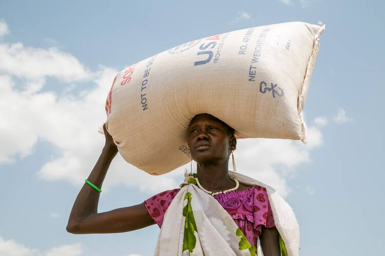 A woman carries food provided by U.S. Agency for International Development in Pajut, South Sudan, March 2017. (CNS photo/Nancy McNally, Catholic Relief Services)